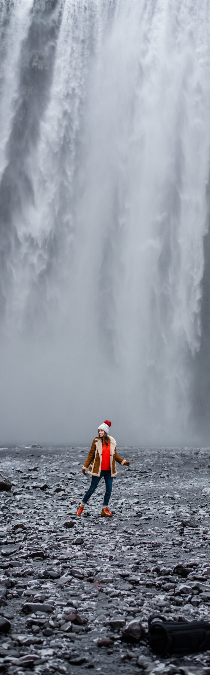 Alyssa Campanella of The A List blog visits Skogáfoss in South Iceland wearing Danner Cascade boots, Topshop faux shearling coat, and ASOS red cable knit sweater.