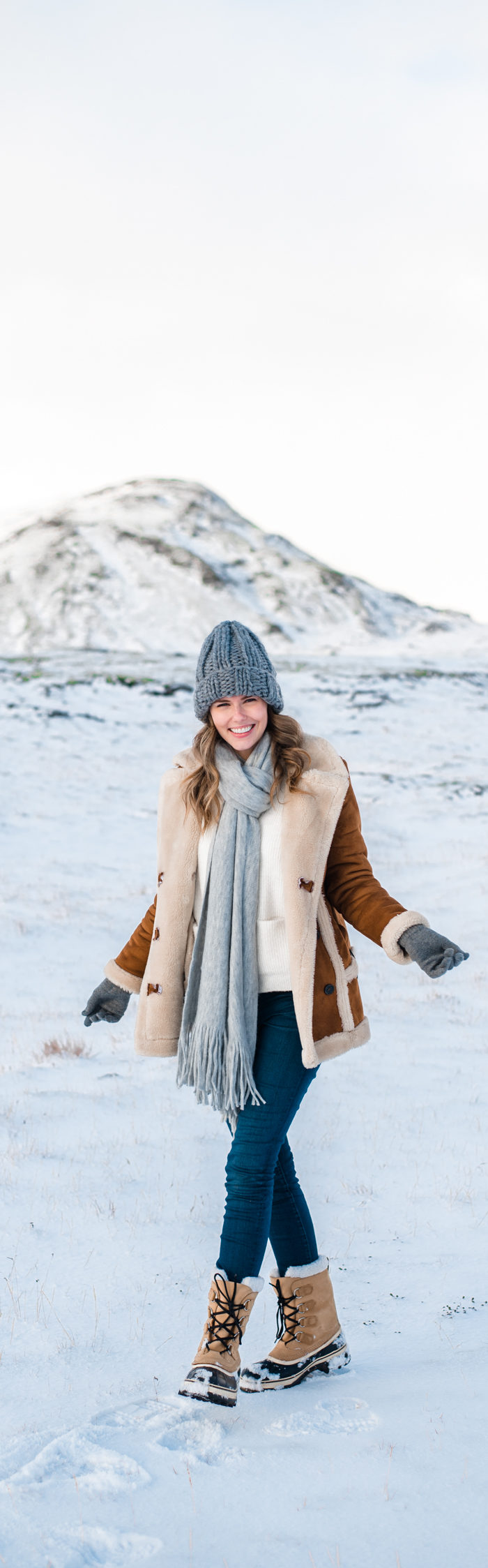Alyssa Campanella of The A List blog plays in the snow in South Iceland wearing Topshop faux shearling coat, Sorel Caribou boots, and ASOS knit beanie