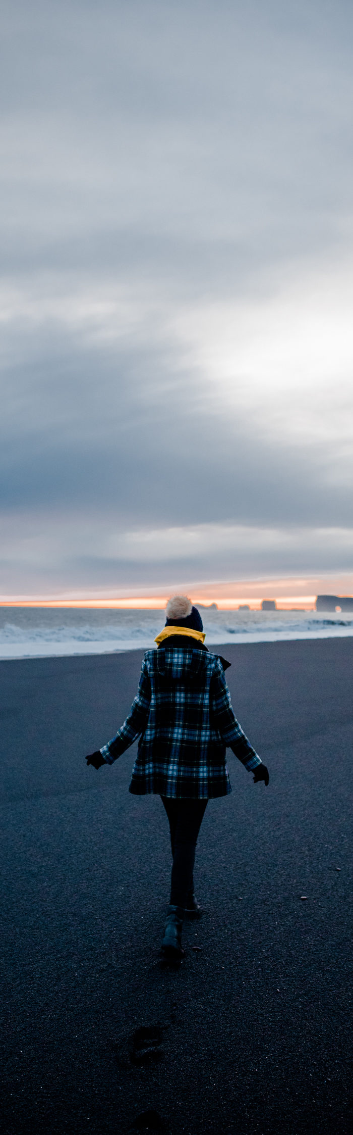 Alyssa Campanella of The A List blog wearing Gloverall plaid coat at Reynisfjara black sand beach on a road trip from Akureyri to Vik, Iceland