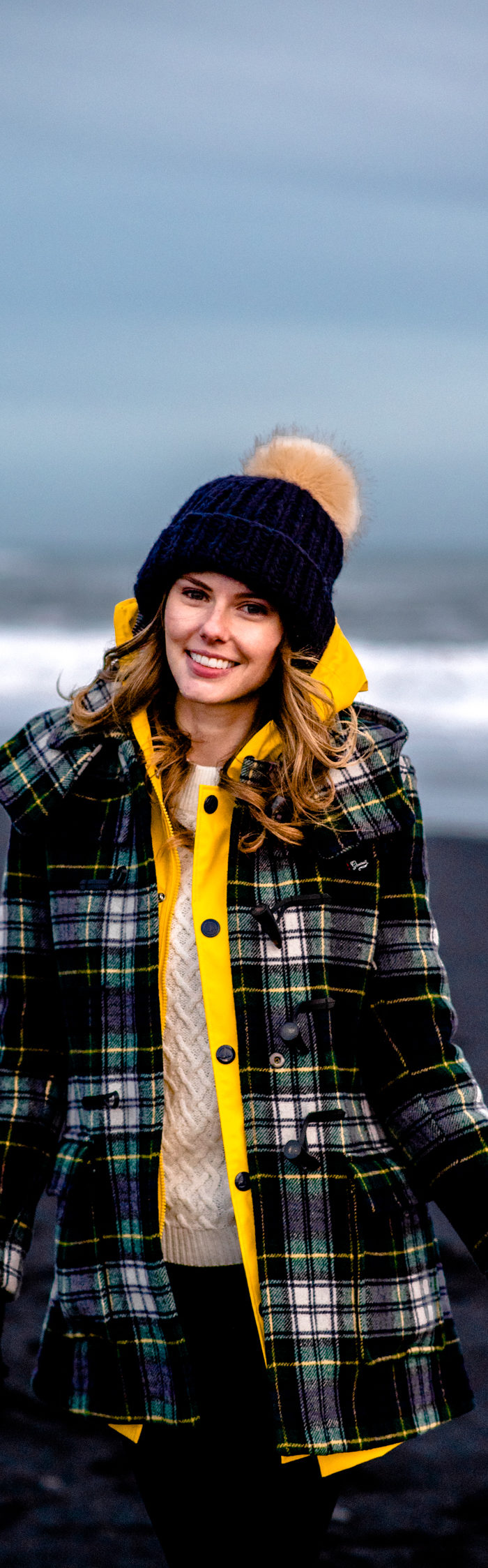 Alyssa Campanella of The A List blog wearing Gloverall plaid coat at Reynisfjara black sand beach on a road trip from Akureyri to Vik, Iceland