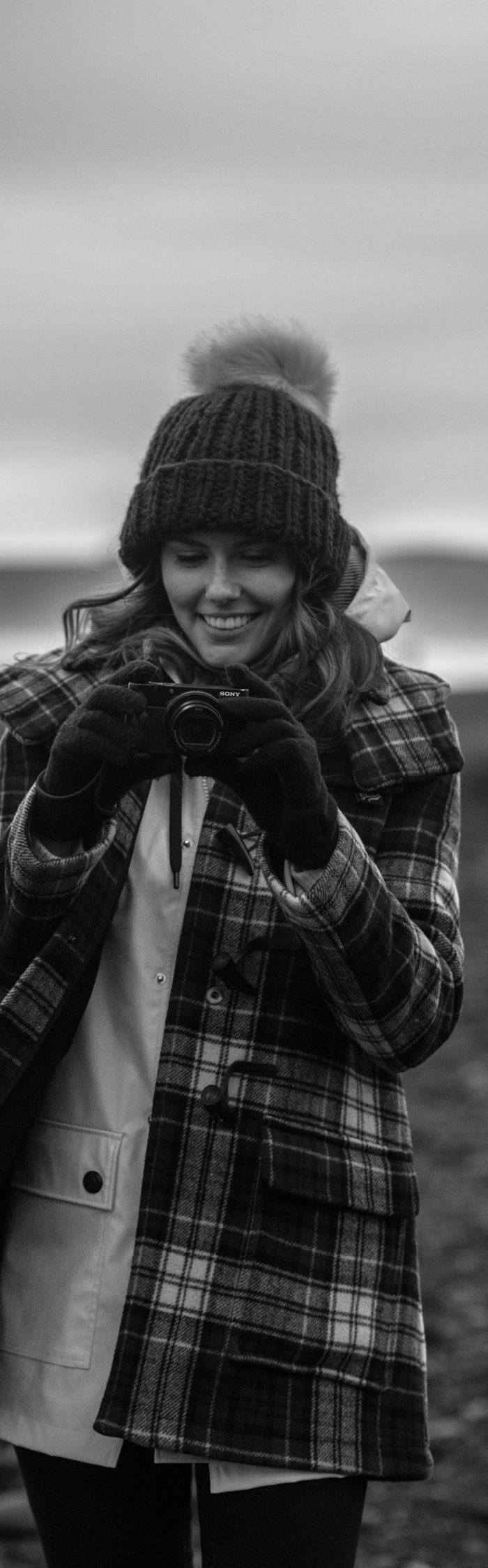 Alyssa Campanella of The A List blog wearing Gloverall plaid coat at Reynisfjara black sand beach on a road trip from Akureyri to Vik, Iceland